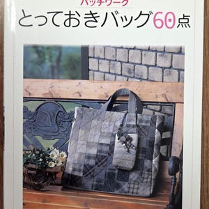 May include: A book cover with a quilted tote bag and a small matching pouch. The book title is in Japanese, with the word "Patchwork" in red. The bag is in shades of grey and black, with a geometric design.