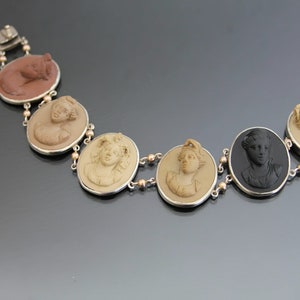 May include: A silver bracelet with six round medallions featuring cameo portraits of women. The medallions are connected by a chain with small gold beads.