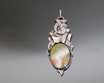 May include: A silver pendant featuring an abstract design and a colourful agate stone in the centre.