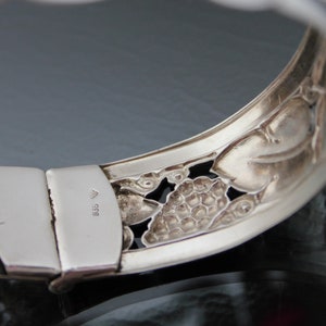 Puede incluir: Pulsera de plata con un dise&ntilde;o floral detallado. El cierre est&aacute; marcado con el n&uacute;mero "835".