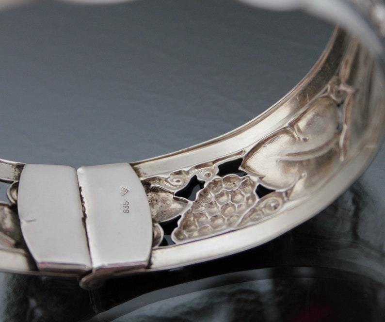Puede incluir: Pulsera de plata con un dise&ntilde;o floral detallado. El cierre est&aacute; marcado con el n&uacute;mero "835".