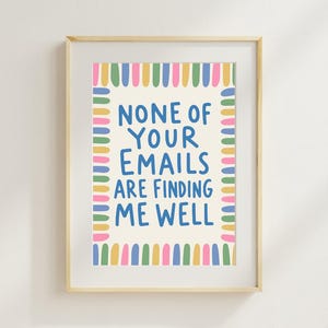 Op de afbeelding: Een ingelijste wandprint met de blauwe tekst NONE OF YOUR EMAILS ARE FINDING ME WELL op een crèmekleurige achtergrond. De tekst is omringd door een rand van kleine, verticale, veelkleurige penseelstreekvormen in roze, geel, blauw en groen.