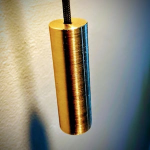 Op de afbeelding: Een gouden metalen trekkoord voor een lamp. De ketting is rond en heeft een geborstelde afwerking.