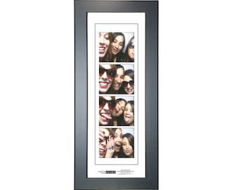 May include: Black photo frame with a white mat and a strip of four photos of women smiling and making silly faces. The photos are arranged vertically in a strip.