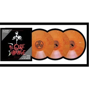 May include: A framed display featuring a vinyl record album. The album cover is black with white and red text and a graphic of a person. Three orange vinyl records are visible. The text on the album cover reads "The Cure Orange".