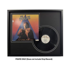 May include: Black framed display for a vinyl record album. The album cover features the band The Police, with the album title "Zenyatta Mondatta". The vinyl record is displayed next to the album cover. The frame is black with a white mat.