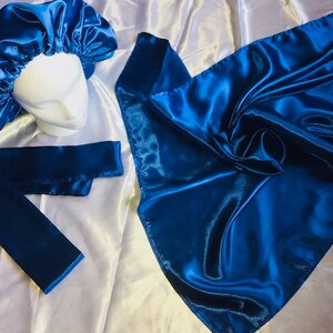 May include: A set of three blue satin hair accessories. The set includes a satin bonnet, a satin scarf, and a satin headband.