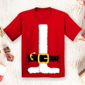 May include: Red t-shirt with a white Santa Claus costume printed on the front. The costume includes a white beard, a black belt with a gold buckle, and a white trim around the collar.