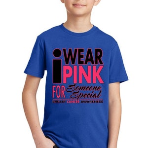 May include: A royal blue t-shirt with the text "I WEAR PINK FOR SOMEONE SPECIAL" in black and pink lettering. The text "BREAST CANCER AWARENESS" is printed in black below the main text.