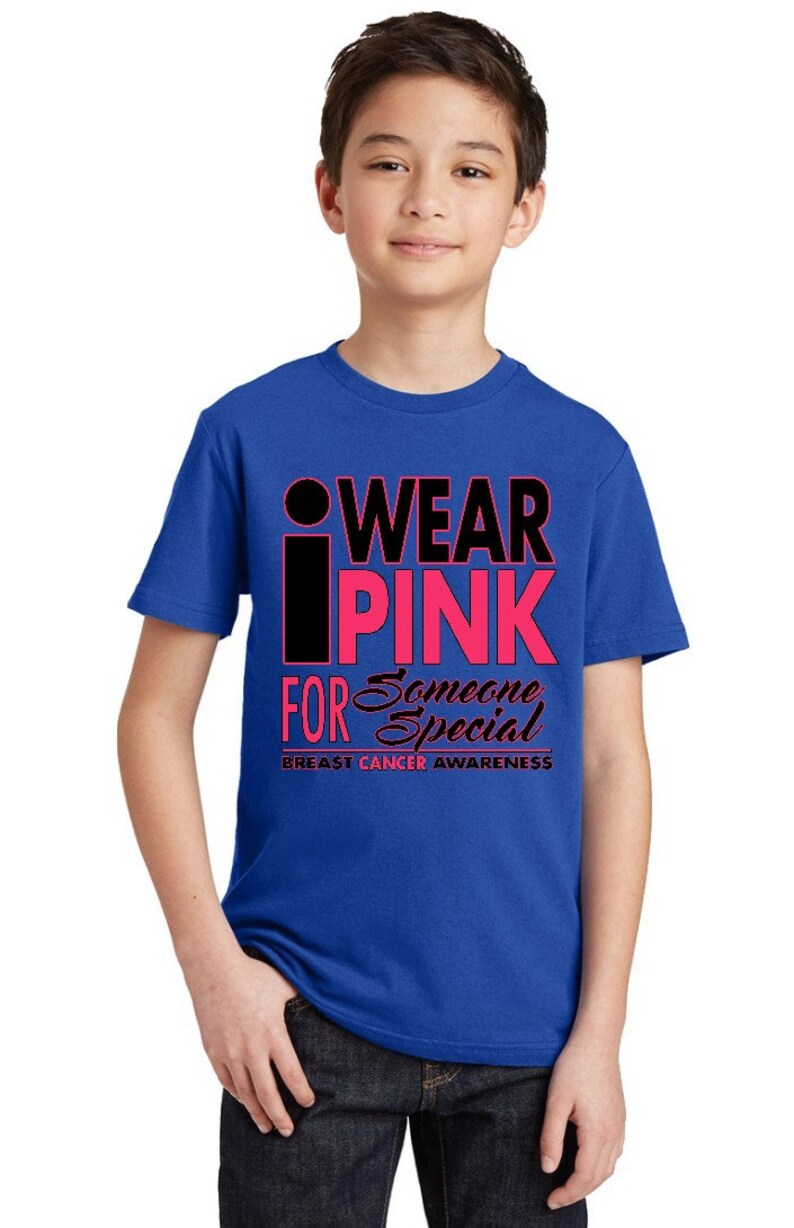 May include: A royal blue t-shirt with the text "I WEAR PINK FOR SOMEONE SPECIAL" in black and pink lettering. The text "BREAST CANCER AWARENESS" is printed in black below the main text.
