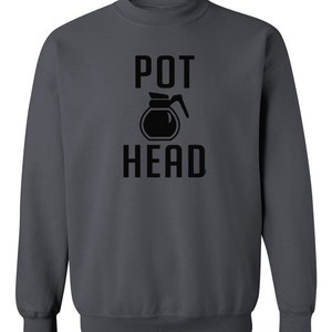 May include: A dark gray sweatshirt with the text "POT HEAD" in black lettering. A black silhouette of a coffee pot is between the words.