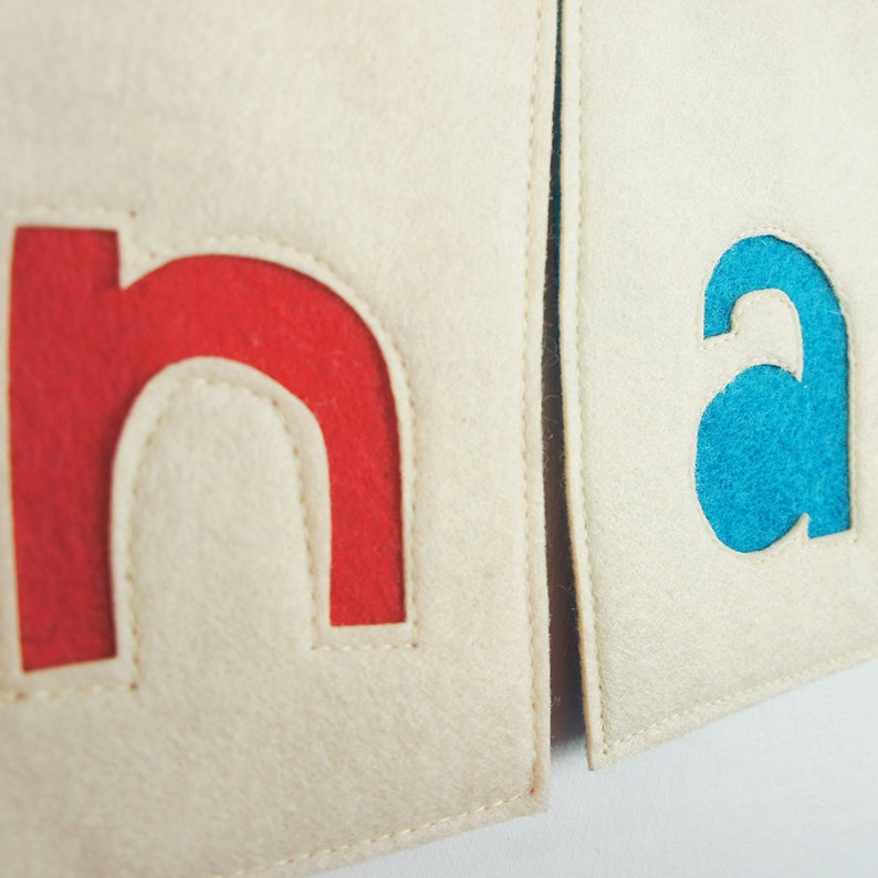 May include: Two felt squares with the letters "n" and "a" cut out. The "n" is red and the "a" is blue.