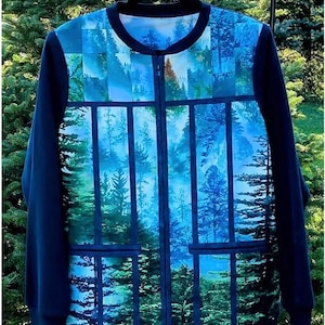 May include: A navy blue zip-up jacket with a forest scene design. The jacket features a vibrant print of trees and a blue sky, with navy blue sleeves and a collar. The jacket has two pockets and a full-length zipper.