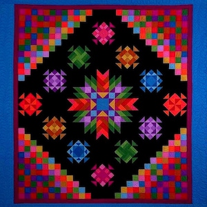 May include: A colorful quilt with a black center featuring geometric star and diamond patterns in vibrant hues of red, orange, yellow, green, blue, and purple. The quilt has a blue border and a purple inner border.