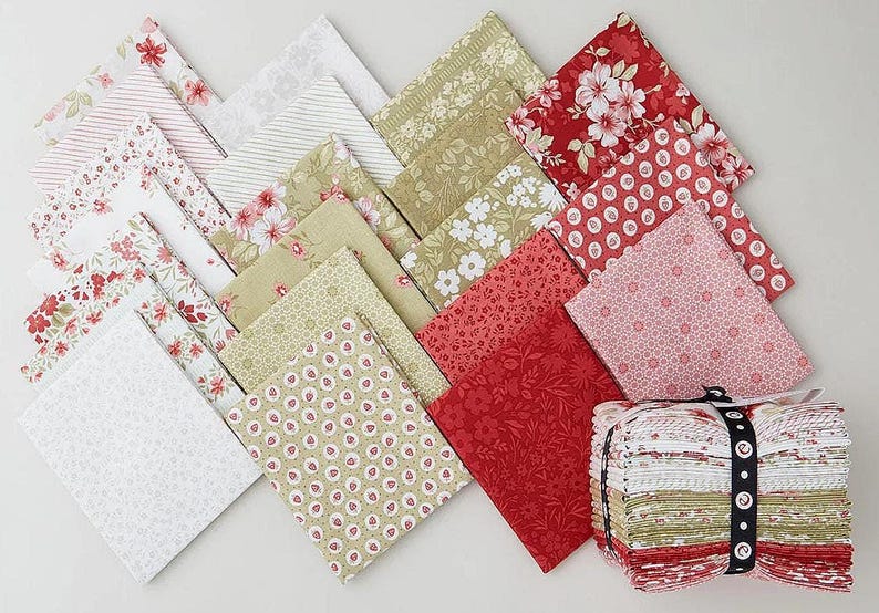 Puede incluir: Una colecci&oacute;n de cuadrados de tela doblados con varios patrones en tonos rojo, blanco y verde oliva. El surtido incluye dise&ntilde;os florales, geom&eacute;tricos y de rayas, con una pila de las mismas telas atadas con una cinta de color negro.