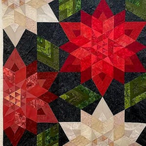 May include: A geometric quilt featuring large red starburst designs, with accents of green and white. The stars are set against a dark background, creating a striking contrast. The quilt is made of various fabric patterns and textures.