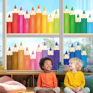 May include: A window decal featuring a colorful array of vertical pencil illustrations in a rainbow spectrum, including red, pink, orange, yellow, green, blue, and purple shades, arranged in a repeating pattern across two window panes.