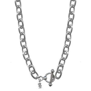 May include: A silver chain necklace with a toggle clasp and a small charm. The chain is made of thick, oval links.
