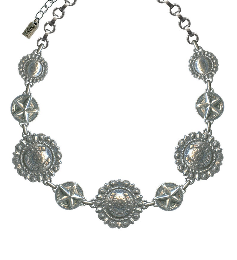 May include: Silver-toned necklace featuring a series of decorative medallions. The necklace includes star and horseshoe motifs, connected by a chain. The design has a Western or Southwestern aesthetic, with a vintage or antique appearance.