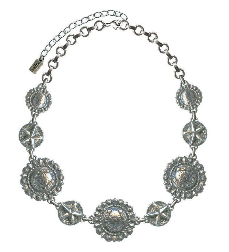 May include: Silver-toned necklace featuring a series of decorative medallions and star-shaped accents. The necklace has a chain with an adjustable length. The medallions have a detailed, textured design. The necklace is designed to be worn around the neck.