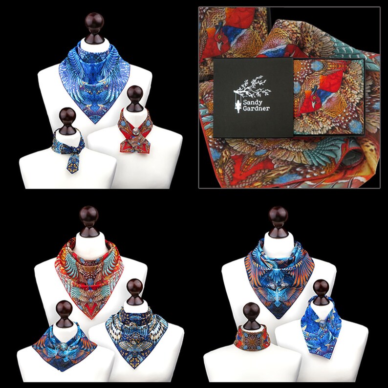 May include: Four neck scarves with different designs featuring birds and feathers. The scarves are displayed on mannequins. The scarves are in shades of blue, red, and orange. The scarves are made by Sandy Gardner.