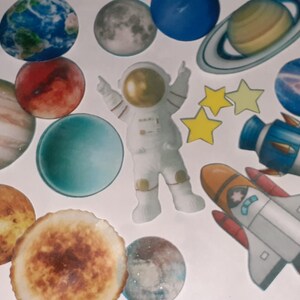 Puede incluir: Un conjunto de pegatinas coloridas con temática espacial que incluyen planetas, estrellas, un astronauta y naves espaciales. Las pegatinas son perfectas para decorar cuadernos, portátiles, botellas de agua y mucho más.
