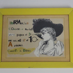 May include: Framed vintage print with a yellow border. The artwork features a black and white illustration of a woman wearing a large hat, with text about journalism. The text includes the words "Journalism", "Buying", and "Selling".