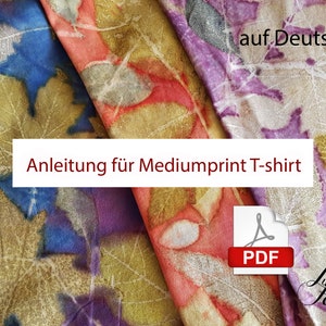 May include: Three fabric swatches with leaf patterns in shades of blue, red, and purple. The fabric is folded and the text "Anleitung für Mediumprint T-shirt" is visible. A PDF icon is in the lower right corner.