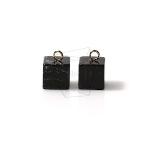 Pode incluir: Dois pingentes quadrados de mármore preto com argolas de salto douradas.