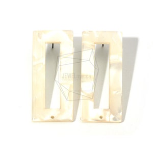 May include: A pair of white rectangular earrings with a cutout design. The earrings have a marbled effect.