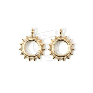 May include: Two gold-toned sun-shaped pendant charms with a circular opening in the center. The charms have a textured, spiky design around the edge.