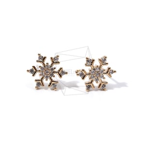 May include: A pair of gold snowflake stud earrings with clear cubic zirconia stones.