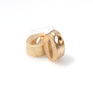 May include: Two gold-coloured metal beads with a hole in the centre. The beads are round and have a smooth surface.