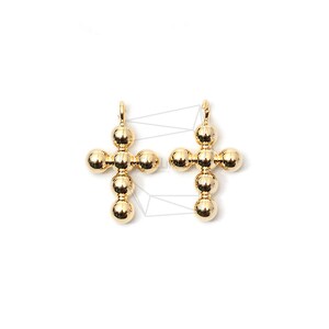 Peut inclure: Deux breloques en forme de croix dorées, composées de petites perles rondes. Chaque breloque en forme de croix a une boucle en haut pour l'attacher à un collier ou un bracelet.