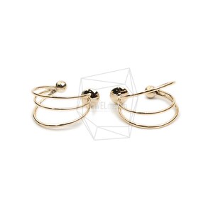 May include: A pair of gold-toned ear cuffs with a triple-ring design. The cuffs are made of thin metal and have a smooth, polished finish.