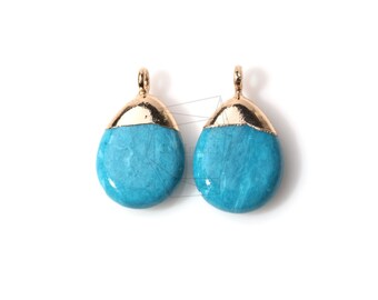 May include: Two turquoise blue and gold teardrop shaped pendant charms. The charms have a gold top and a turquoise blue bottom.