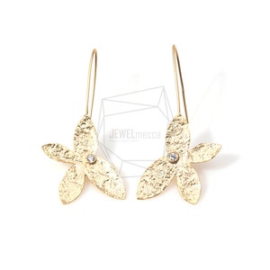 May include: Gold flower-shaped earrings with a small clear rhinestone in the center of each flower. The earrings have a long, thin wire that hangs down from the flower.