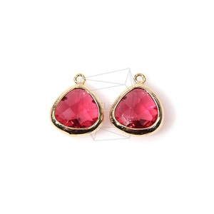 May include: Two gold-tone pendant charms with a teardrop-shaped red crystal.