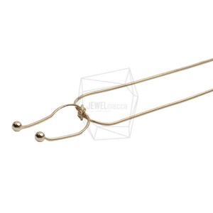 May include: A gold-toned necklace with a stethoscope-shaped pendant and two small round beads at the ends.
