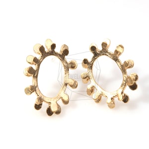 May include: A pair of gold-toned earrings with a unique, organic, sunburst-like design. Each earring features a circular, open-work design with a textured, slightly irregular edge.