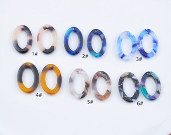May include: Six pairs of oval-shaped resin earrings with different patterns. The earrings are in various colors, including brown, blue, and white. The earrings are numbered 1 through 6.