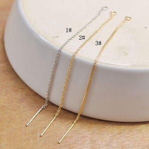Puede incluir: Tres cadenas doradas y plateadas sobre una superficie blanca. Las cadenas están etiquetadas como 1#, 2# y 3#.