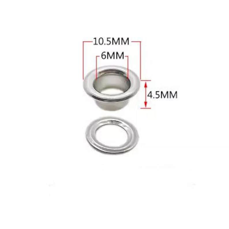 Może przedstawiać: Srebrne metalowe oczka o średnicy zewnętrznej 10,5 mm, średnicy wewnętrznej 6 mm i wysokości 4,5 mm. Oczka są używane do prac ręcznych i projekt&oacute;w szycia.