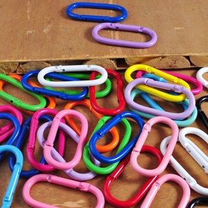 May include: A collection of colorful metal key rings in various shapes and sizes. The key rings are made of metal and have a smooth finish. They are a great way to add a pop of color to your keys or bag.