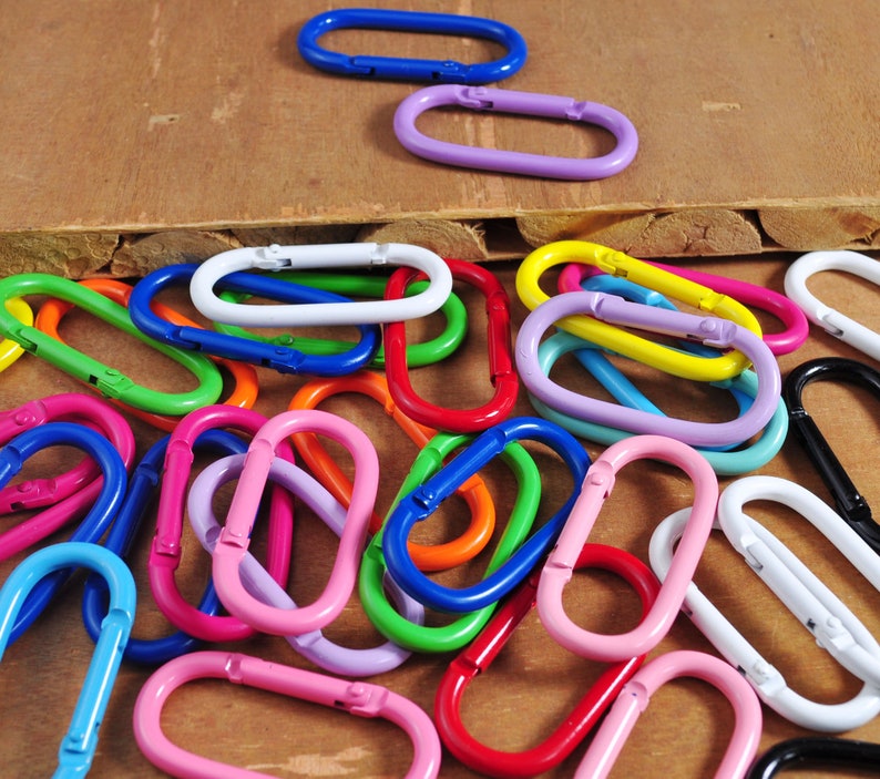 May include: A collection of colorful metal key rings in various shapes and sizes. The key rings are made of metal and have a smooth finish. They are a great way to add a pop of color to your keys or bag.