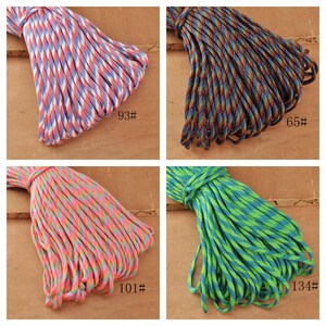 May include: Four bundles of colorful paracord in various patterns. One bundle is red, white, and blue; another is a mix of blue, green, and brown; a third is pink and orange; and the last is green and blue. Each bundle has a number label.