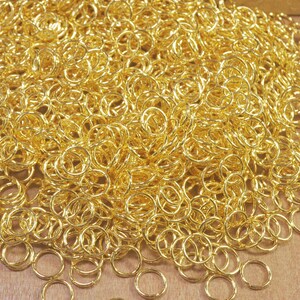 Puede incluir: Un mont&oacute;n grande de anillos de salto de metal de color dorado. Los anillos son todos del mismo tama&ntilde;o y est&aacute;n dispuestos en un patr&oacute;n aleatorio.