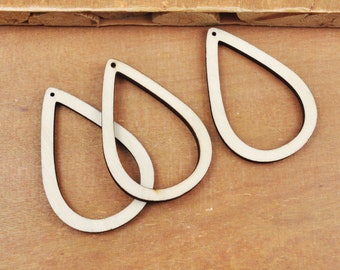 May include: Three unfinished wooden teardrop shapes with a hole at the top. The shapes are arranged in a semi-circle on a wooden surface.