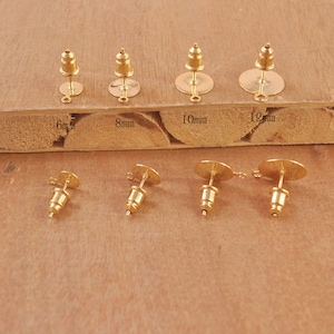 May include: Four pairs of gold-tone earring posts with different sized backings. The backings are 6mm, 8mm, 10mm, and 12mm in diameter.