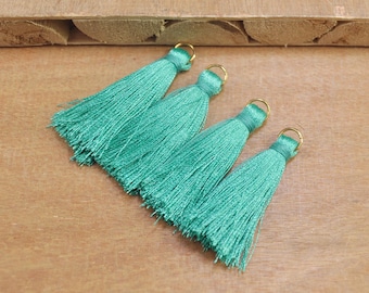 Puede incluir: Cuatro borlas de color azul turquesa con anillos de metal dorado. Las borlas están hechas de hilos suaves y sedosos y son perfectas para agregar un toque de elegancia a cualquier proyecto.